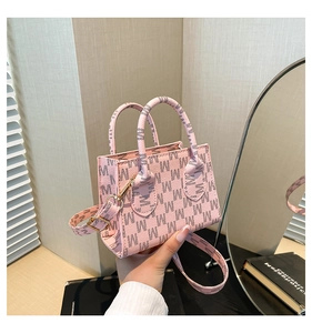 Dettaglio della borsa in pelle rosa con motivo M e finiture dorate