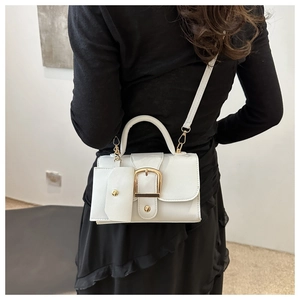 White leather crossbody bag with gold buckle and mini pouch shown on a model