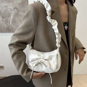 Chic beige pleated crescent bag with bow decoration and ruffled shoulder strap