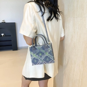 Women's denim crossbody bag featuring green stars and fringe details for casual street style
