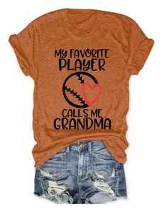Detail eines orangen Baumwoll-T-Shirts mit Baseball-Herz-Print und verwaschenen Jeans
