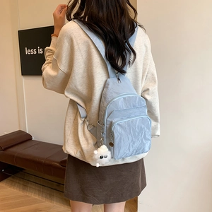 Sac bandoulière polyvalent en nylon bleu clair avec poches zippées et pompon blanc