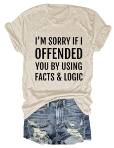 Detail of beige slogan T-shirt tucked into ripped denim shorts on white background