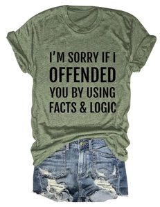 Flat lay of olive green crew neck tee with facts & logic quote and denim shorts