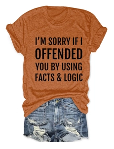 Detail of orange cotton T-shirt featuring 'FACTS & LOGIC' slogan print and denim shorts
