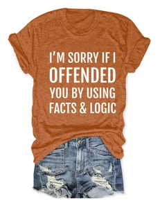 Detail of orange t-shirt with slogan print paired with blue distressed denim shorts
