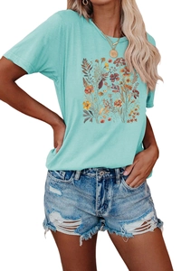 Detalle de camiseta floral verde menta con pantalones cortos de mezclilla desgastados