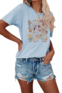 Detalle del estampado floral en camiseta de mujer azul claro con cuello redondo y manga corta