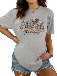 Détail du t-shirt gris Occupational Therapy avec fleurs et short en jean effiloché