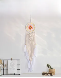 Detail of hand-woven dreamcatcher with orange net, white feathers and wooden beads