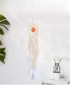 Detailed view of handmade bohemian dream catcher with feathers and colorful mesh on wall