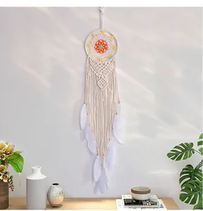 Detailed handmade crochet wall tapestry with white feathers and warm wooden beads