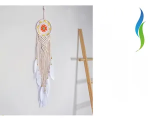 Detailed view of bohemian hand-woven macrame wall hanging with feathers and wooden beads