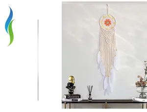 Detail of handcrafted cream macrame dream catcher with colorful accents on a white wall