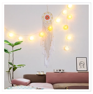 Detailed handmade macrame dream catcher with floral pattern, white feathers and wooden beads