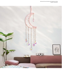 Detail of pink moon dreamcatcher with crystal pendants in a minimalist room