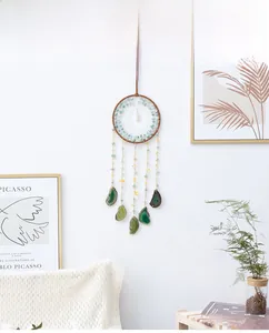 Macro detail of dream catcher wall hanging with green agate slices and raw stones