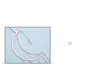 Detail of pink rose quartz dreamcatcher with crescent moon frame and handmade tree of life