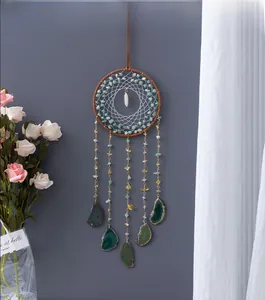 Detail of bohemian dream catcher featuring natural agate slices and gemstone accents