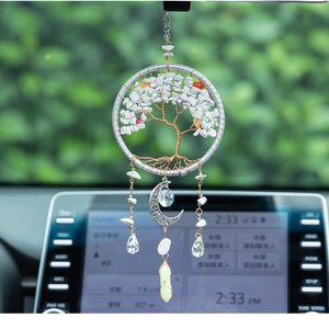 Macro detail of white crystal life tree car hanging charm with silver moon pendant