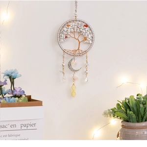 Macro detail of Tree of Life crystal moon pendant with white stones on a white wall
