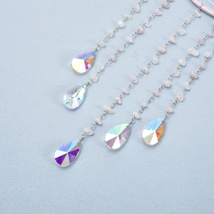 Handmade pink rose quartz suncatcher with AB crystal teardrop pendants on blue background