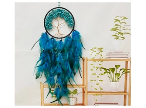 Détail d'un attrape-rêve Arbre de Vie avec pierres turquoises et plumes bleues sur mur