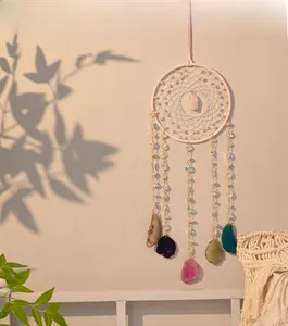 Detail of pink crystal dreamcatcher with colorful natural agate slices and woven net