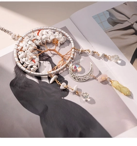 Macro detail of a silver Tree of Life pendant with white stones and crystal charms