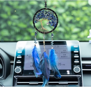 Detail view of handmade tree of life car charm with blue crystals and feathers