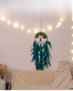 Detail of life tree dream catcher with green stones and hanging teal feathers