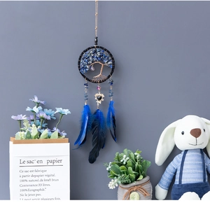 Detail of life tree dreamcatcher car charm with blue crystals and soft feathers