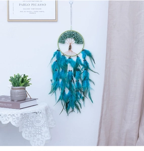 Detail of Tree of Life dream catcher with green aventurine stones and feathers on wall