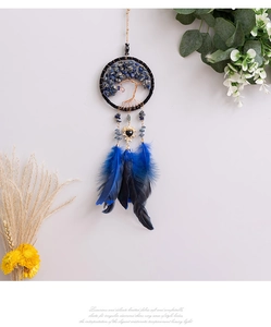 Macro detail of Tree of Life car pendant with blue crystals and dark feathers
