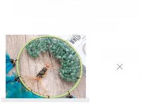Detail of tree of life suncatcher with green stones, owl charm and peacock feathers