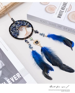 Detail of a blue dream catcher car charm with a life tree and navy blue feathers