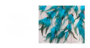 Close-up of vibrant blue and green feathers with dark brown wooden beads on light wood