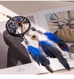 Macro shot of Tree of Life dreamcatcher car pendant with blue stones and soft feathers