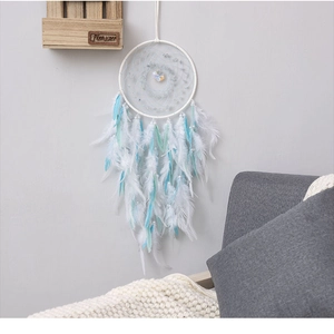 Detail of bohemian dream catcher featuring soft white and light blue feathers with pearls