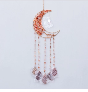 Detail of moon-shaped suncatcher with red stone tree of life and crystal pendant