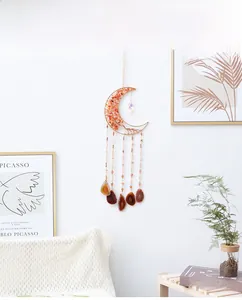 Detail of moon-shaped suncatcher with red crystals and natural agate slices decor