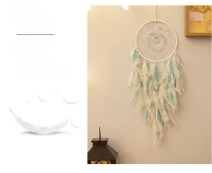 Detail of bohemian dream catcher featuring white feathers and blue accents for room decor