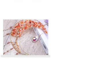 Detailed view of handmade golden tree of life suncatcher with red crystals and prisms