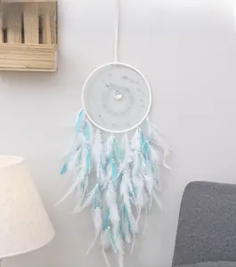 Detail of dream catcher wall hanging with white mesh, blue feathers and crystal beads