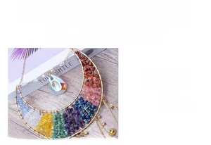 Detail of moon-shaped crystal dreamcatcher with colorful natural stones and gold metal chain