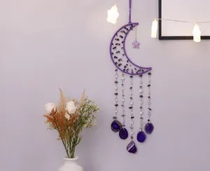 Detail of moon-shaped amethyst dream catcher with hanging crystal beads and agate slices