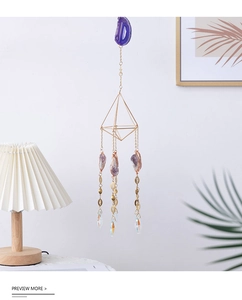 Detail of amethyst crystal suncatcher with golden geometric frame and hanging prism drops
