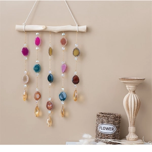 Detail of hanging agate wind chime with natural wood branch and colorful gemstone slices