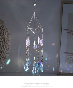Detail of crystal suncatcher with geometric frame, purple raw stone and rainbow prism