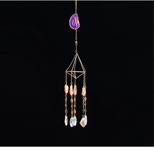 Detail of amethyst suncatcher with golden geometric frame and crystal prism ball